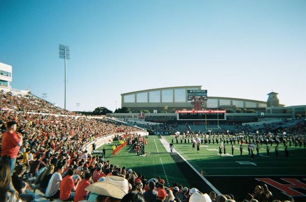 Estádio lotado em noite de jogo, com foco na torcida vibrando