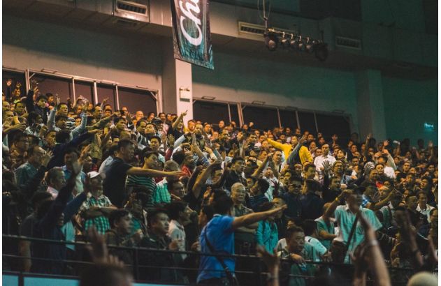 Pessoas sentadas em uma cadeira dentro de um prédio